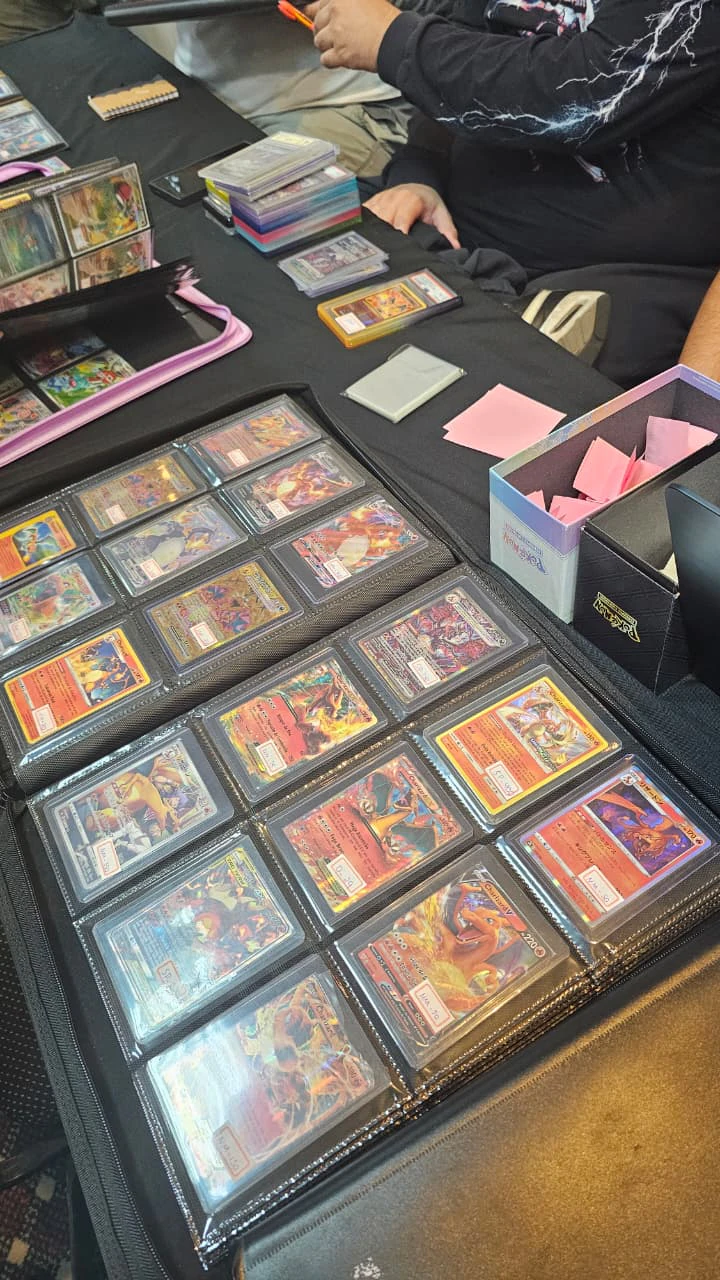 Open binder full of Charizard cards on one of the Conclave trading tables